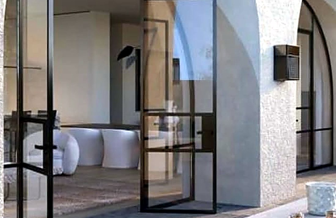 Freshly rendered and painted home exterior with steel-framed glass doors and archways