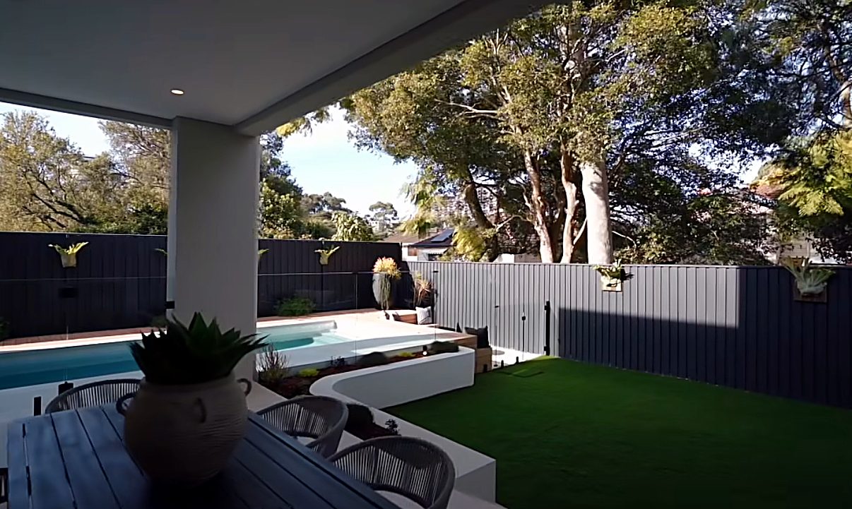 Landscaped backyard with pool, glass fencing, alfresco area and fresh turf